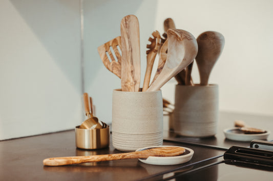 olive wood kitchen utensils next to the stove